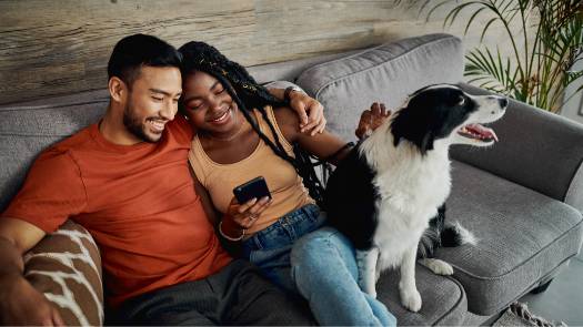 A dog on the couch with their owners