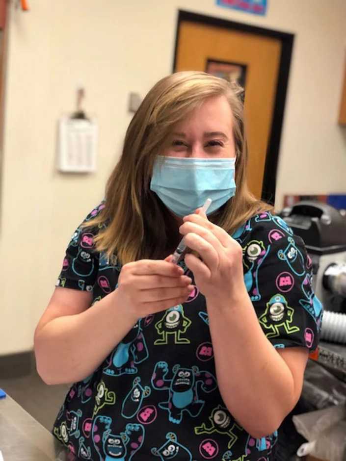 A female associate holding a syringe at the Banfield Pet Hospital